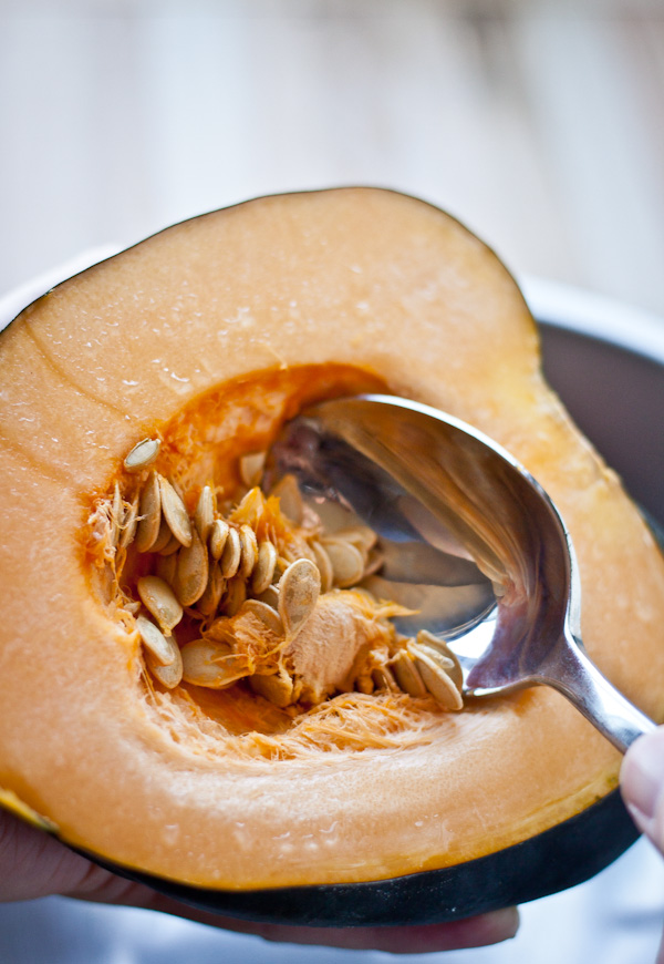Halved Acorn Squash with Spoon Scooping Out Seeds