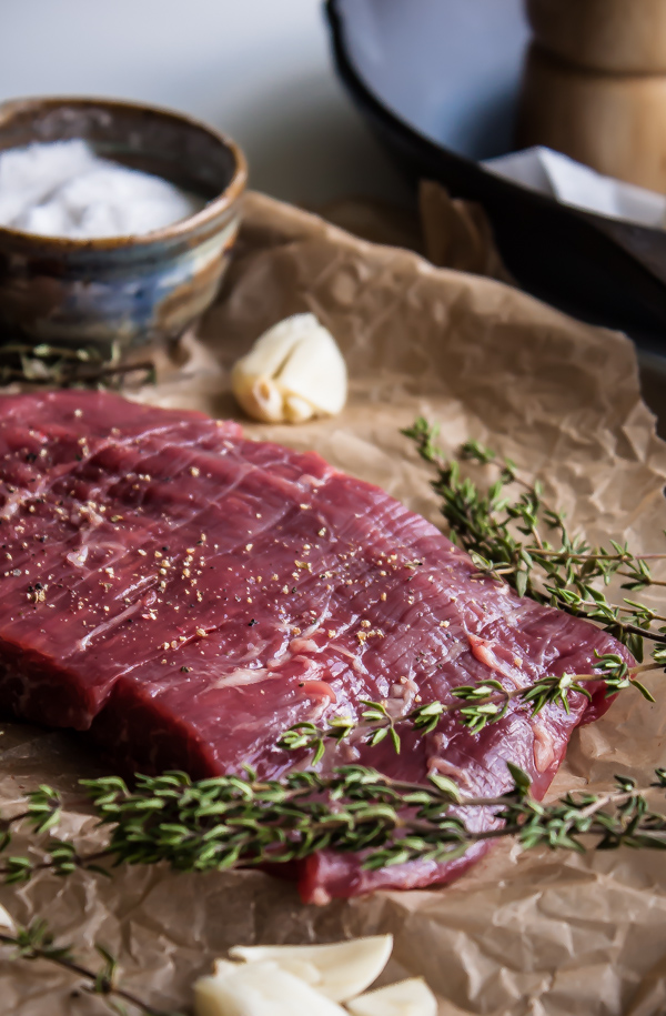 Raw Flank Steak Seasoned with Salt and Pepper