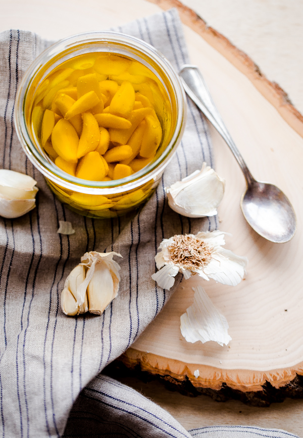 Homemade Garlic Confit and Garlic Oil in Jar on Cutting Board
