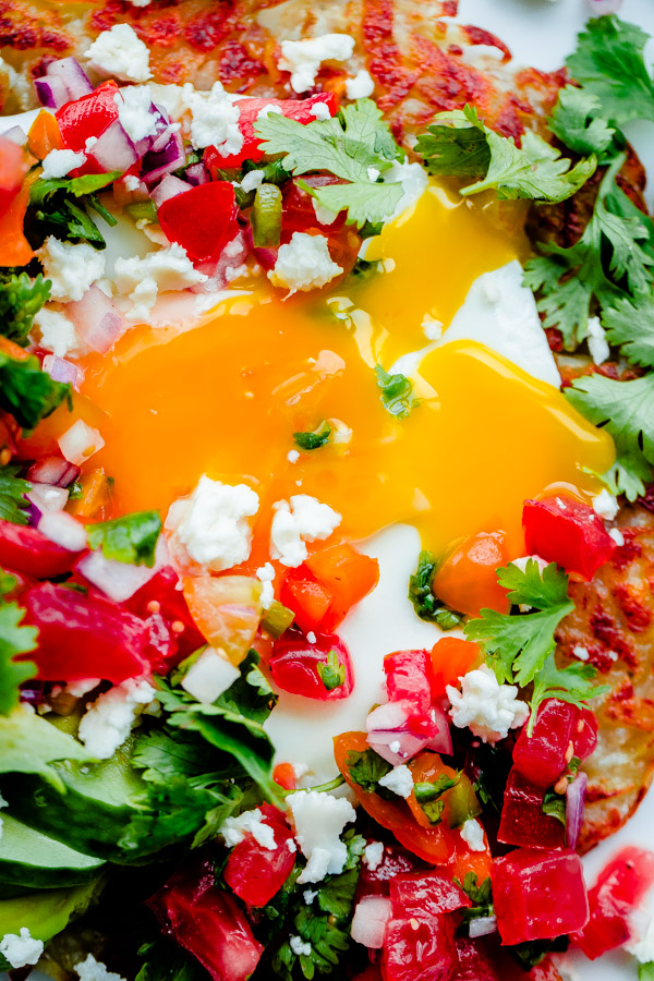 Mexican Hash Brown Stack. Crispy potato topped with sunny-side eggs, sliced avocado, homemade pico de gallo, and crumbled queso fresco cheese! 