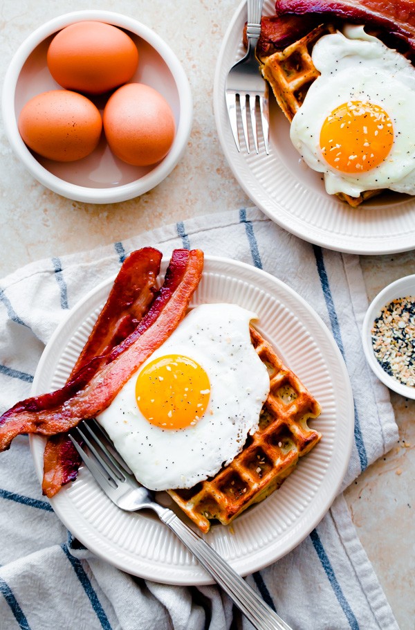 Everything Bagel Breakfast Waffles. Topped with sunny-side eggs and crispy bacon!