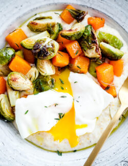 Creamy Goat Cheese Grits with Roasted Brussels Sprouts and Squash and Poached Eggs. A delicious, EASY vegetarian dinner recipe!