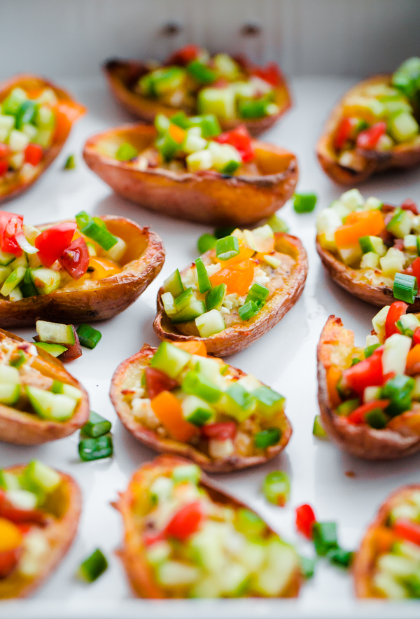 Greek-Style Potato Skins with Hummus. A HEALTHY and easy potato skin recipe made with hummus, feta, and chopped vegetables - a great party or tailgating appetizer!