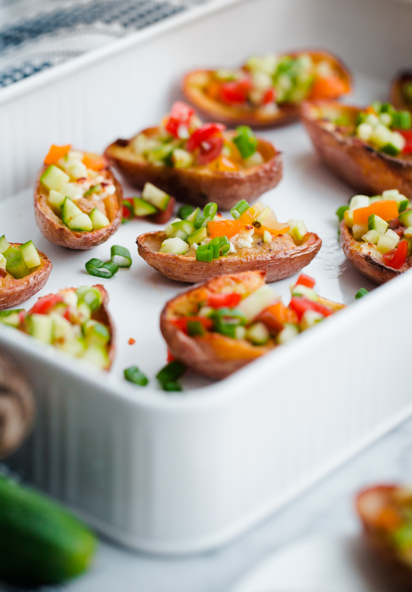 Greek-Style Potato Skins with Hummus. A HEALTHY and easy potato skin recipe made with hummus, feta, and chopped vegetables - a great party or tailgating appetizer!