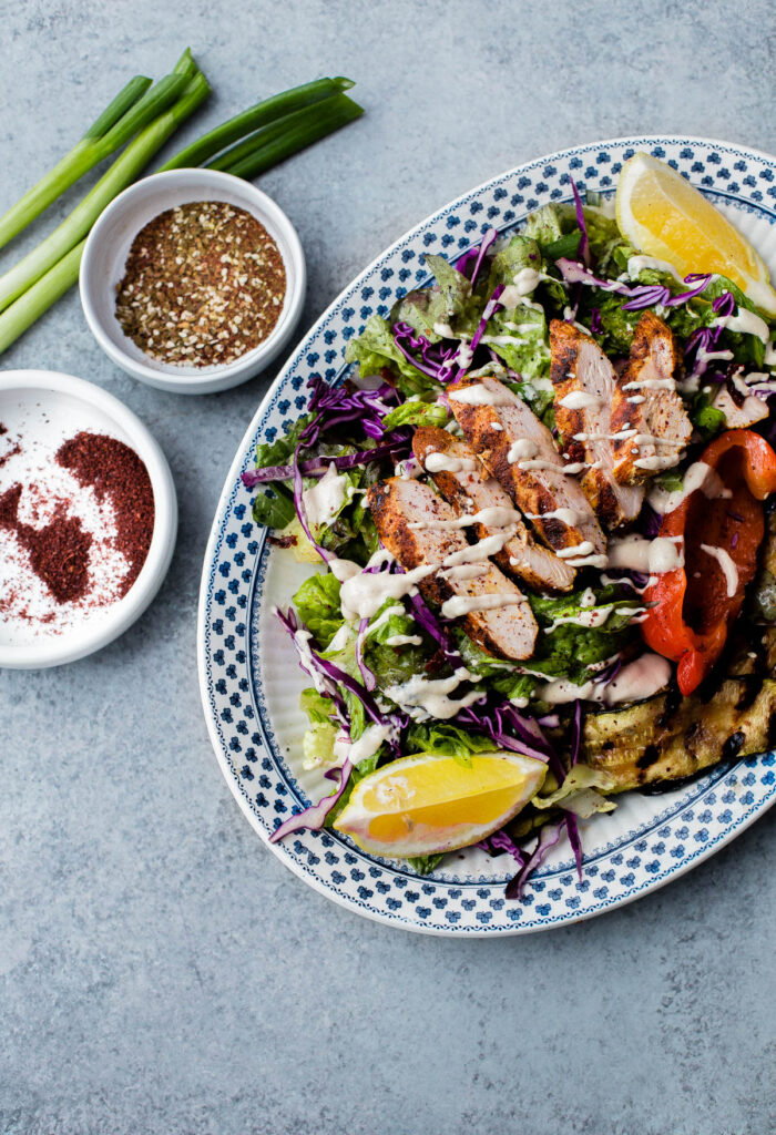 AMAZING Mediterranean Chicken Salad with Sumac Dressing. This salad is packed with flavor and is topped with tahini dressing!