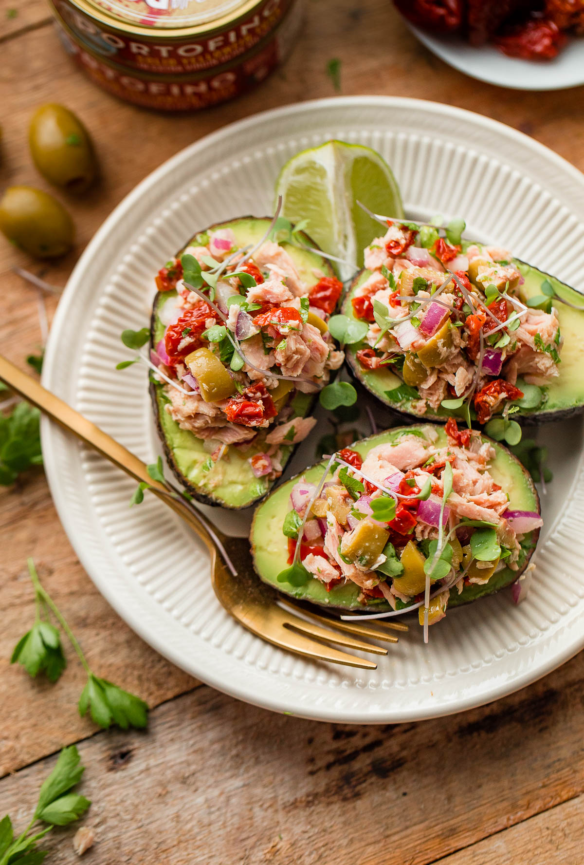 Italian Tuna Avocado Boats - fresh tuna salad made with Bella Portofino extra virgin olive oil packed yellowfin tuna, olives, sundried tomatoes, parsley, and lime served in avocado boats. An easy, healthy, dairy free, gluten free, and paleo friendly recipe!