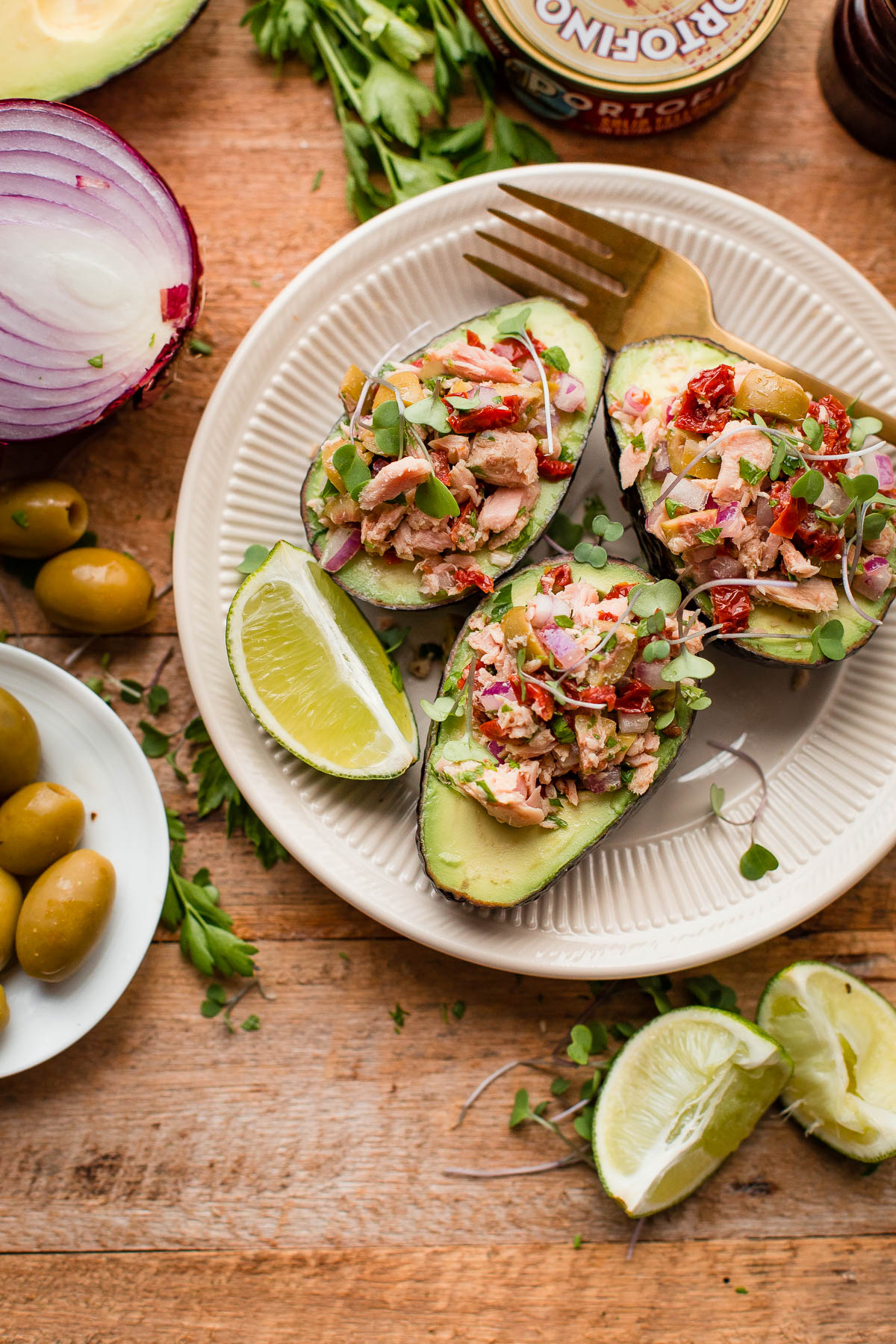 Italian Tuna Avocado Boats - fresh tuna salad made with Bella Portofino extra virgin olive oil packed yellowfin tuna, olives, sundried tomatoes, parsley, and lime served in avocado boats. An easy, healthy, dairy free, gluten free, and paleo friendly recipe!