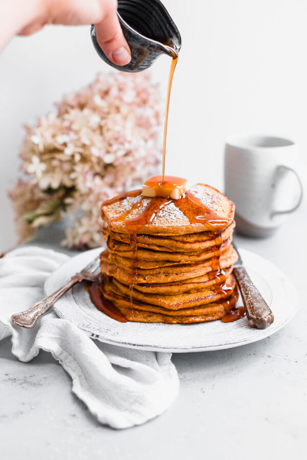 Maple Syrup Pouring On Top of Pumpkin Pancakes 