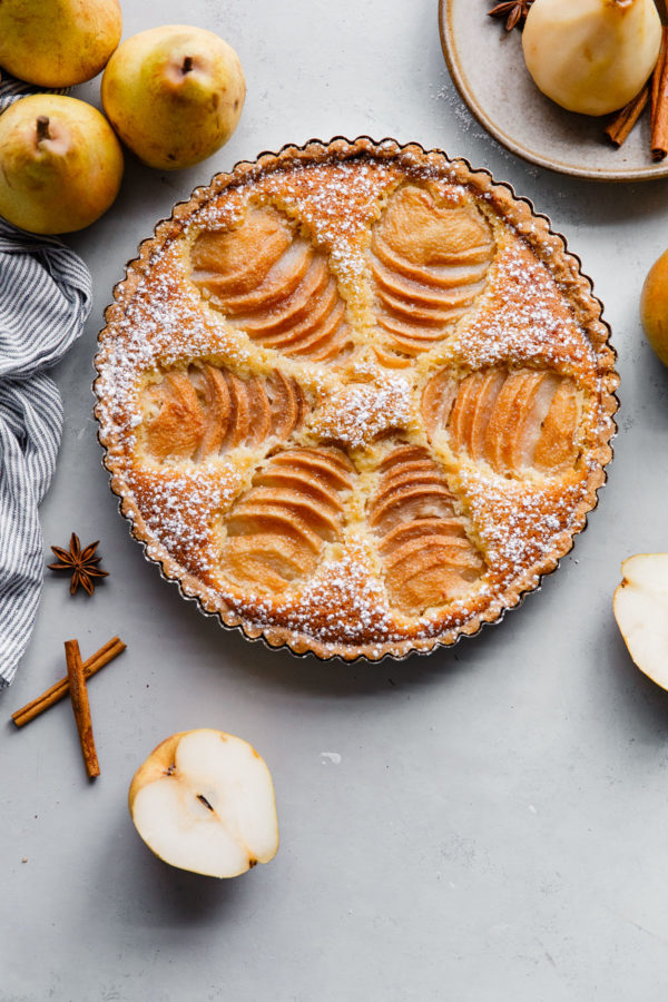 Pear Frangipane Tart - this classic French poached pear tart recipe is made with a sweet tart dough and filled with poached pears and frangipane (almond cream). This tart is delicious and is wonderful served on Thanksgiving or over the holiday season! Top with powdered sugar or apricot glaze. #tart #recipe #abeautifulplate #pear #frangipane #poached #French #dessert #pastry