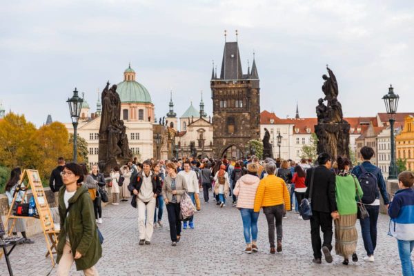 People walking across Charles Bridge in Prague