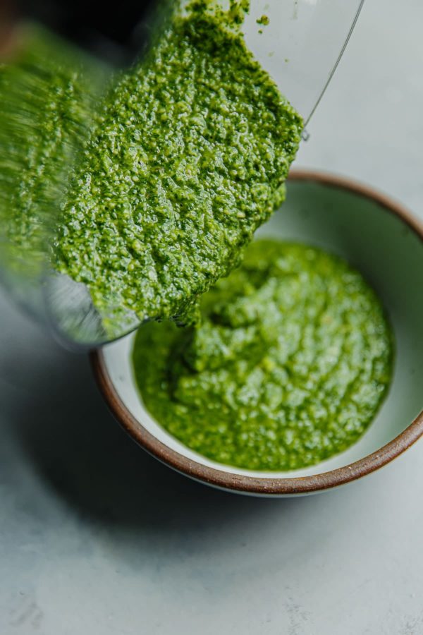 Arugula Pesto Being Poured into Bowl