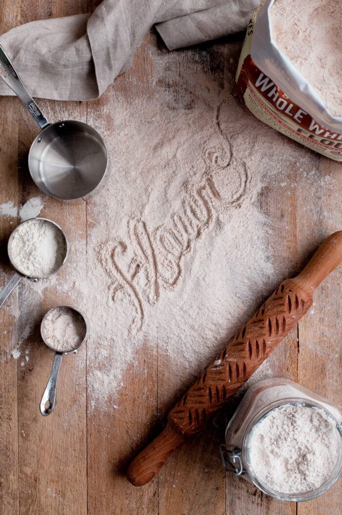 Flour Dusted on Wood Board with Measuring Cups