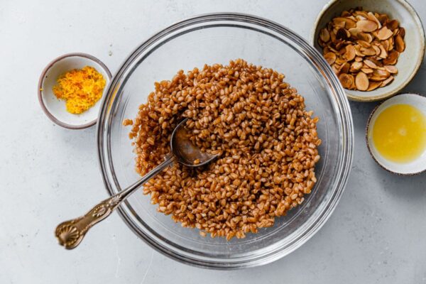 Cooked Farro in Bowl with Orange Zest, Orange Juice, and Sliced Almonds