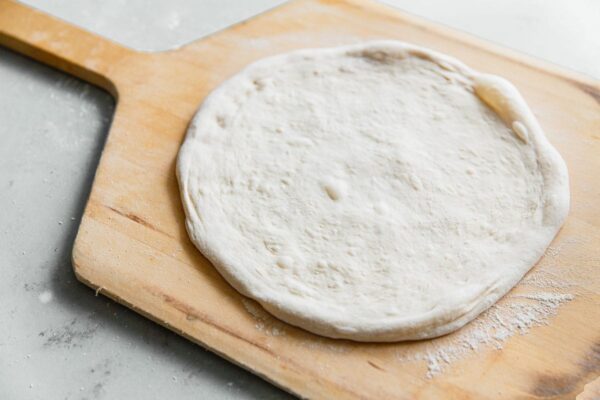 Stretched Sourdough Pizza Dough on Wooden Pizza Peel