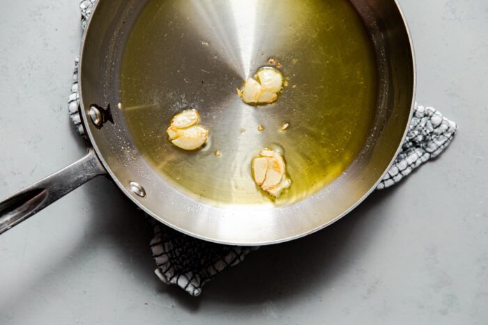 Smashed Garlic Cloves in Skillet with Olive Oil
