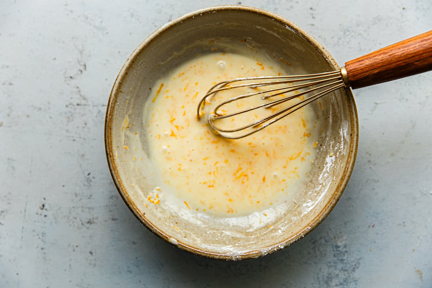 Powdered Sugar Orange Glaze in Bowl with Whisk